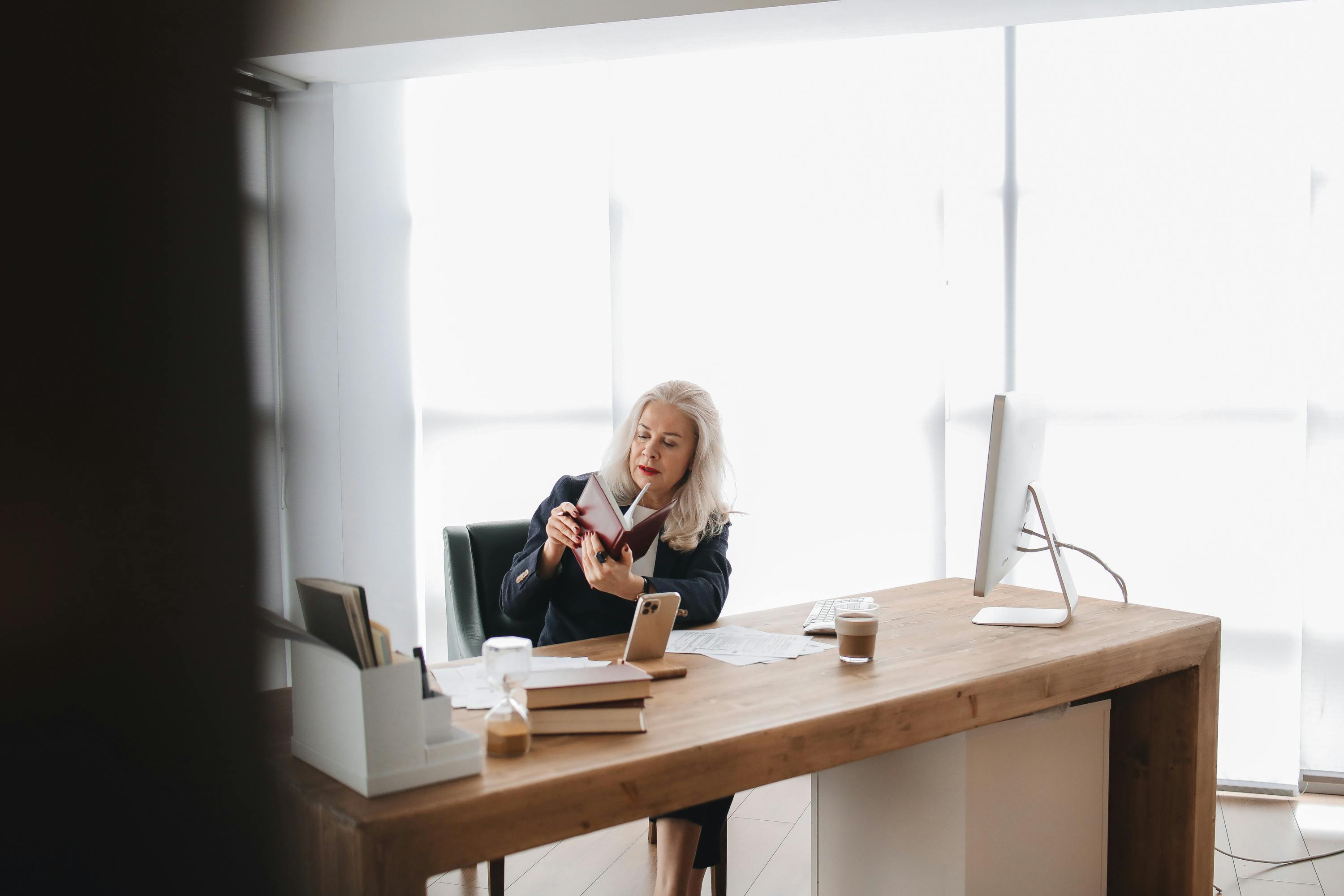 Woman reviewing notebook at her desk