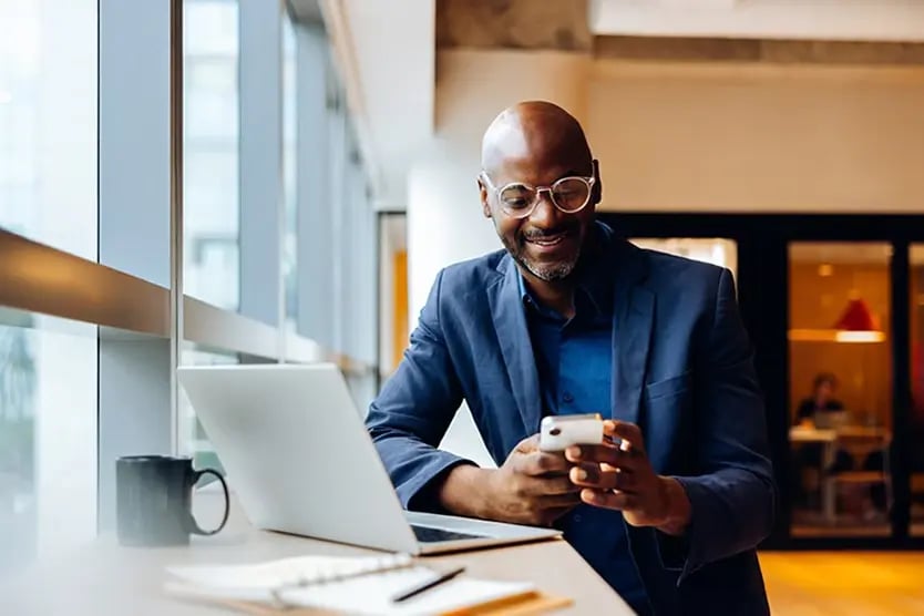 A person at ease, reviewing his experienced registered investment advisor's email on his mobile phone.