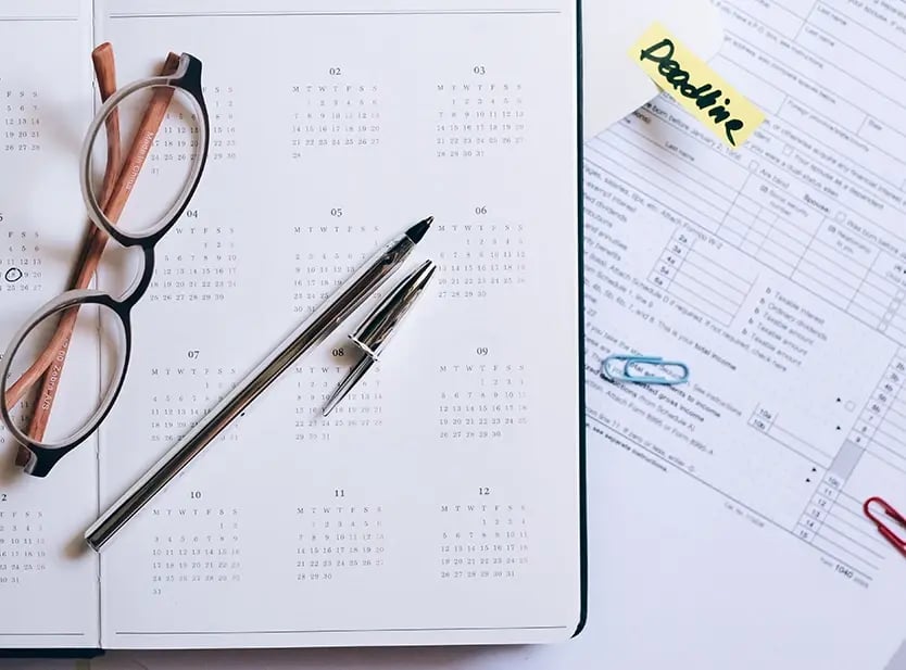 Calendar open on the desk with a deadline noted.