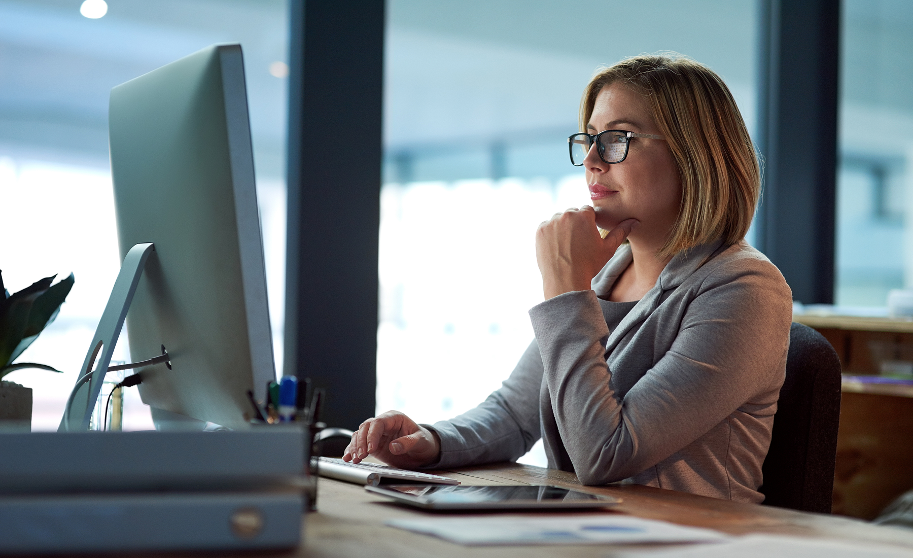 Business person seated in front of their computer.